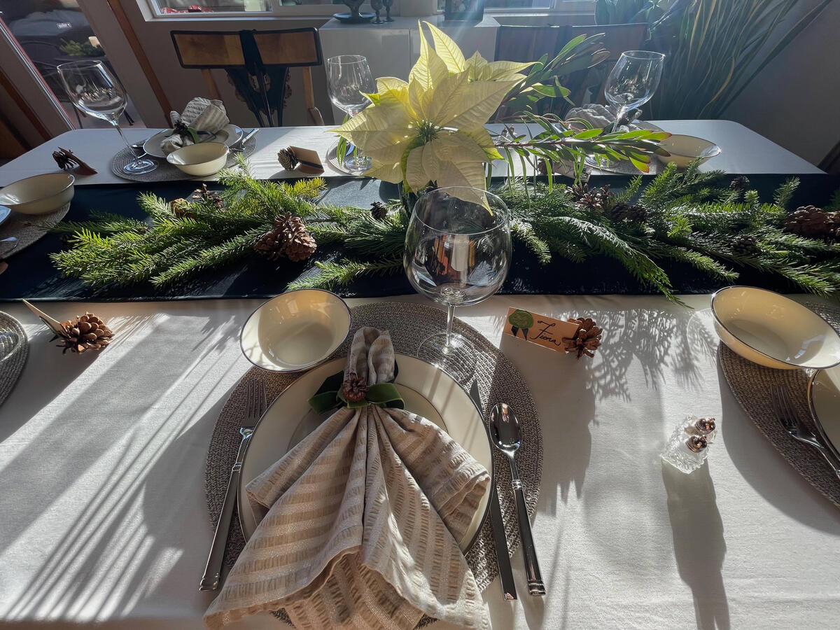 Lenox Montclair china returns in a winter setting, layered with pinecones, evergreen foliage, and candlelight.